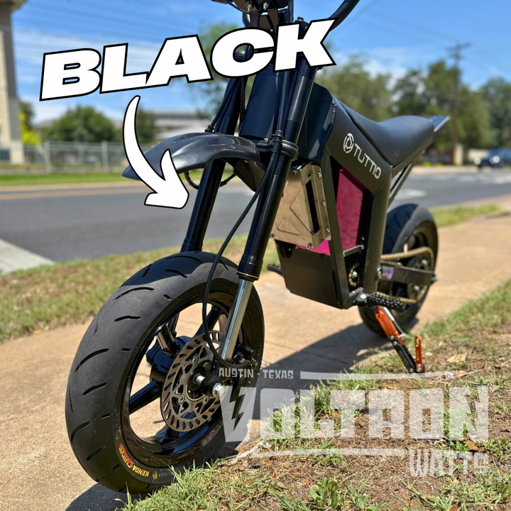 Black electric scooter with 'Tutto' branding on a grassy area.