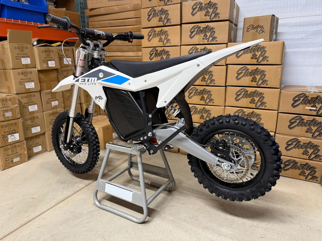 Electric dirt bike on a stand with boxes in the background