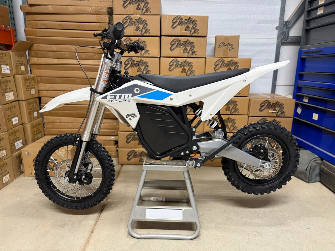 White electric bike on a stand with boxes in the background