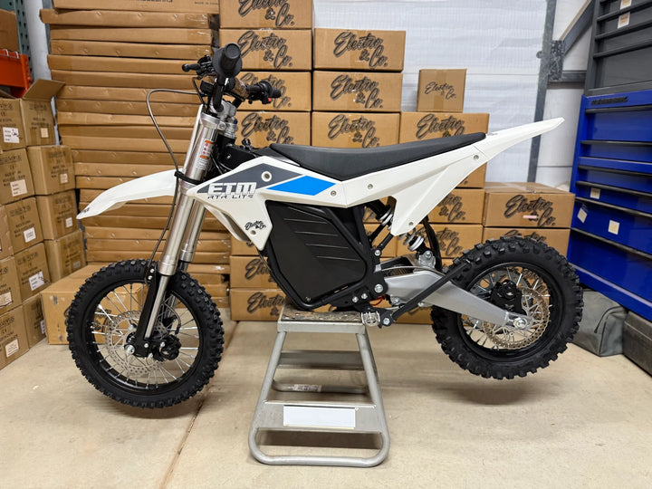 White electric bike on a stand with boxes in the background
