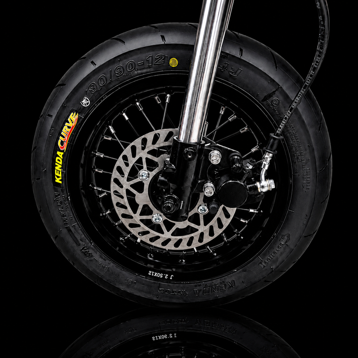Close-up of a motorcycle wheel with disc brake on a black background