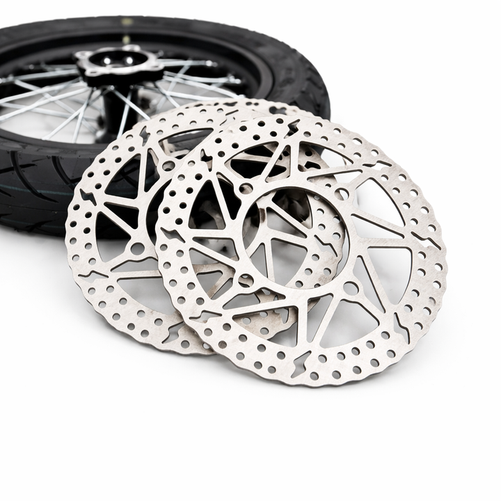 Motorcycle brake disc with a wheel in the background on a white background
