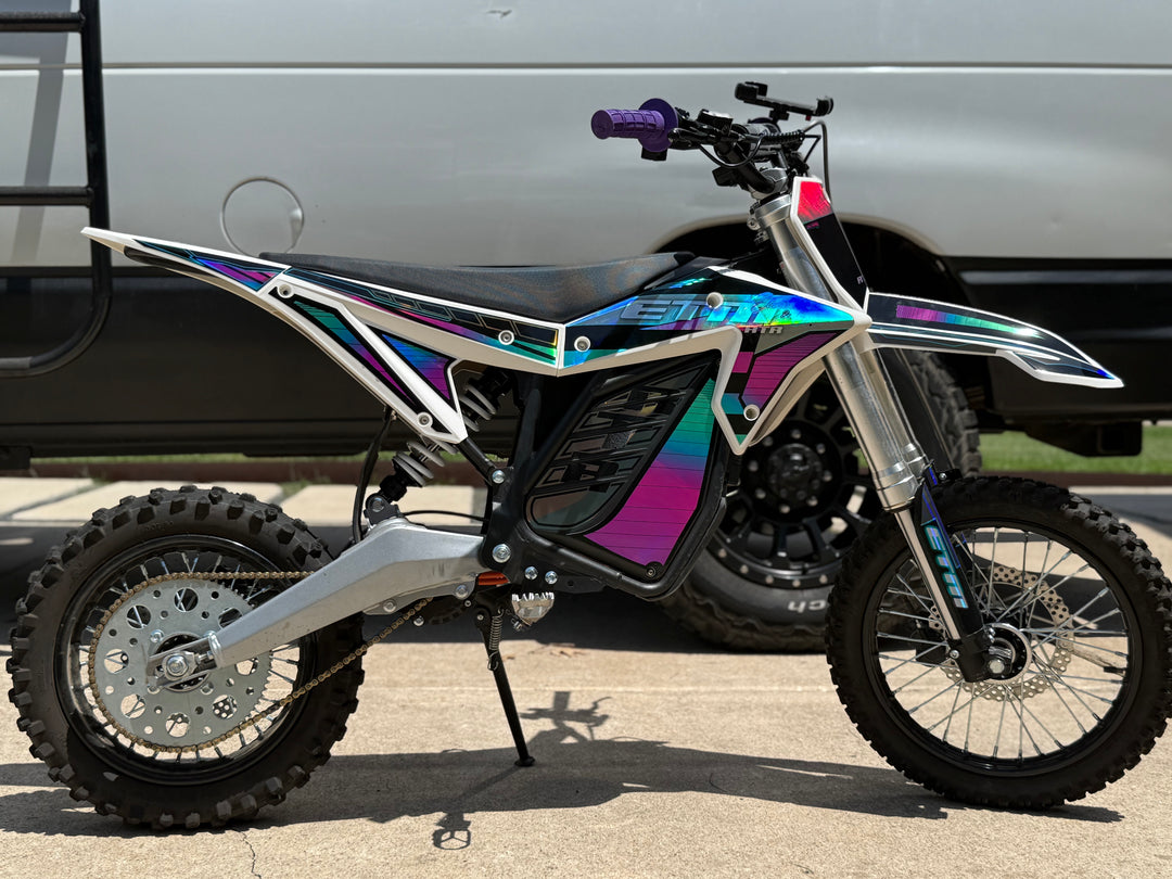 Motorcycle with a colorful design parked next to a van.