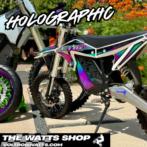 Motorcycle with holographic design on a street, featuring 'The Watts Shop' branding.