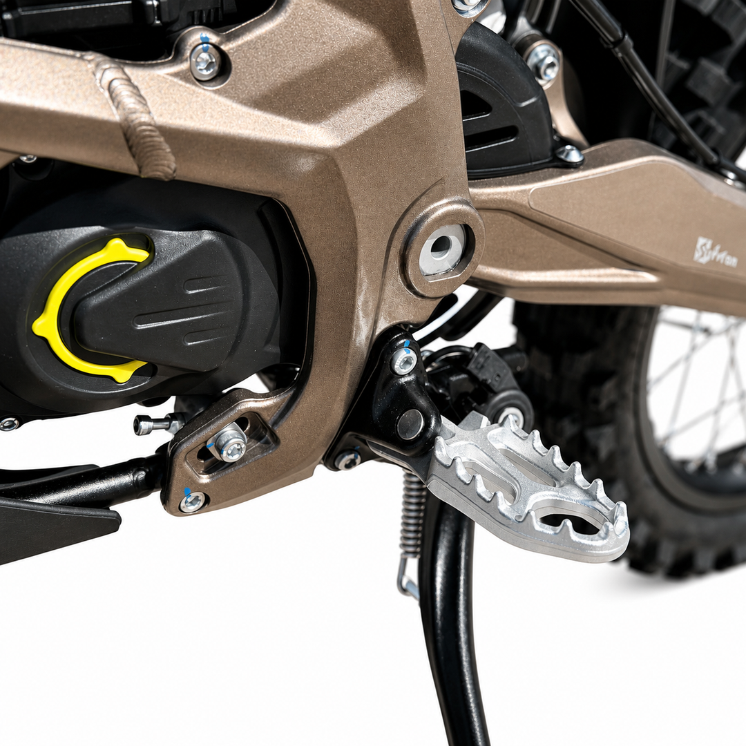 Close-up of a motorcycle's foot peg and engine area on a white background