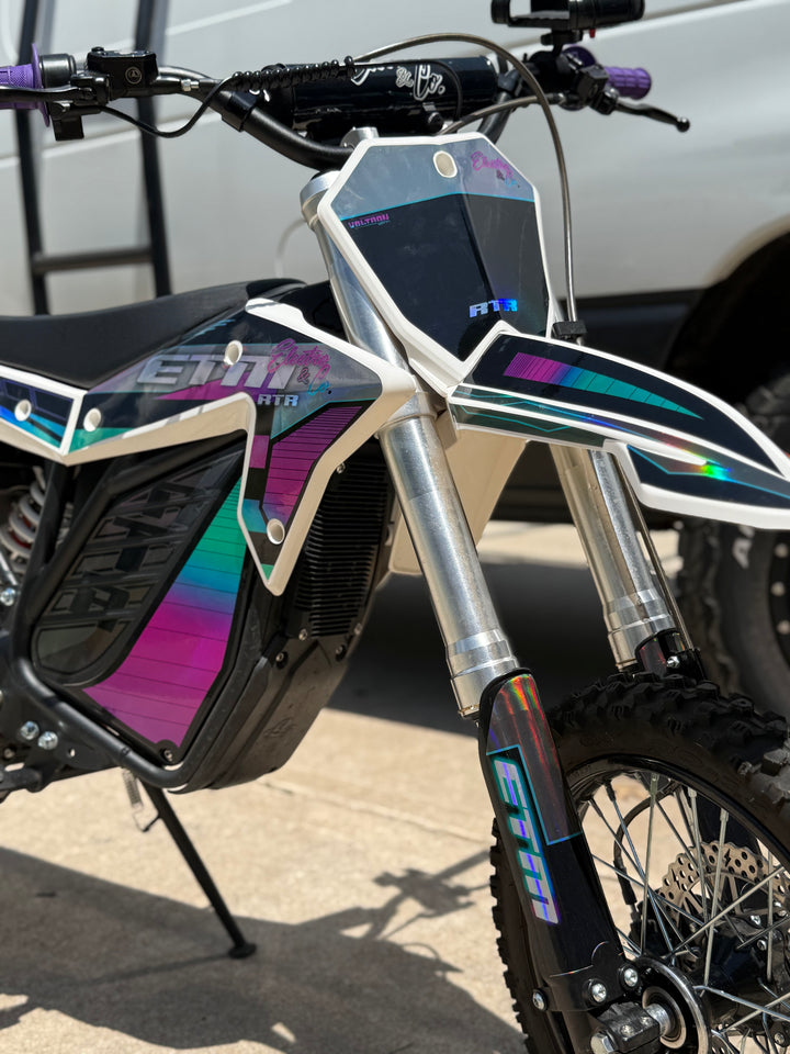 Close-up of a dirt bike with colorful design on a concrete surface