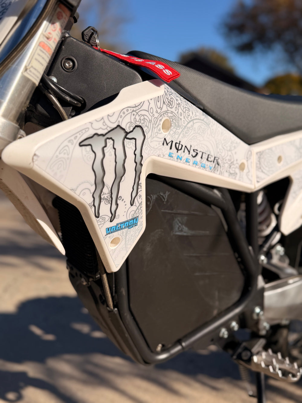 Close-up of a motorcycle seat with Monster Energy branding.