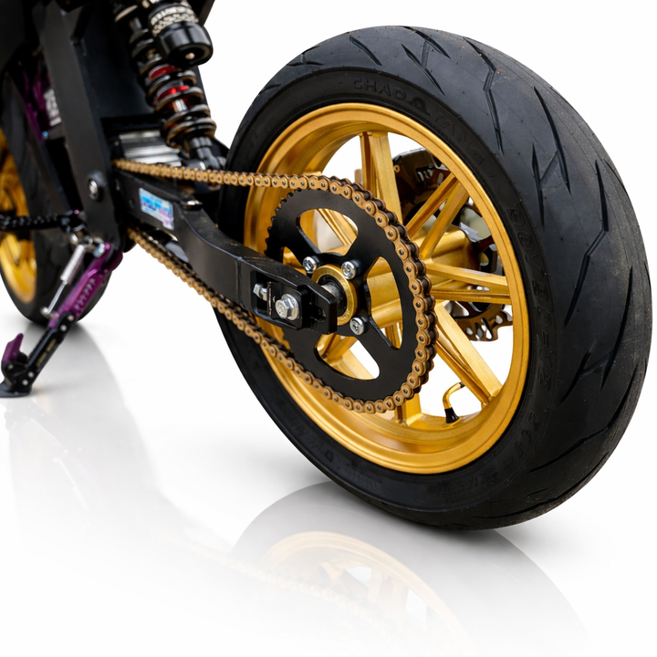 Close-up of a motorcycle wheel with gold rim and black tire on a white background