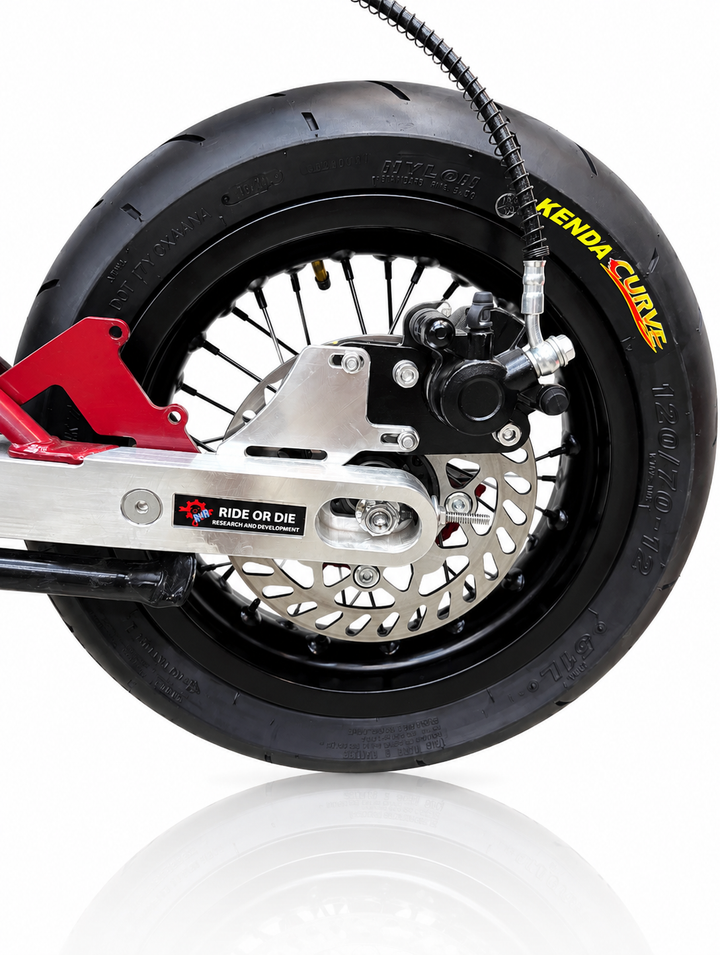 Close-up of a motorcycle wheel with Kenda tire on a white background