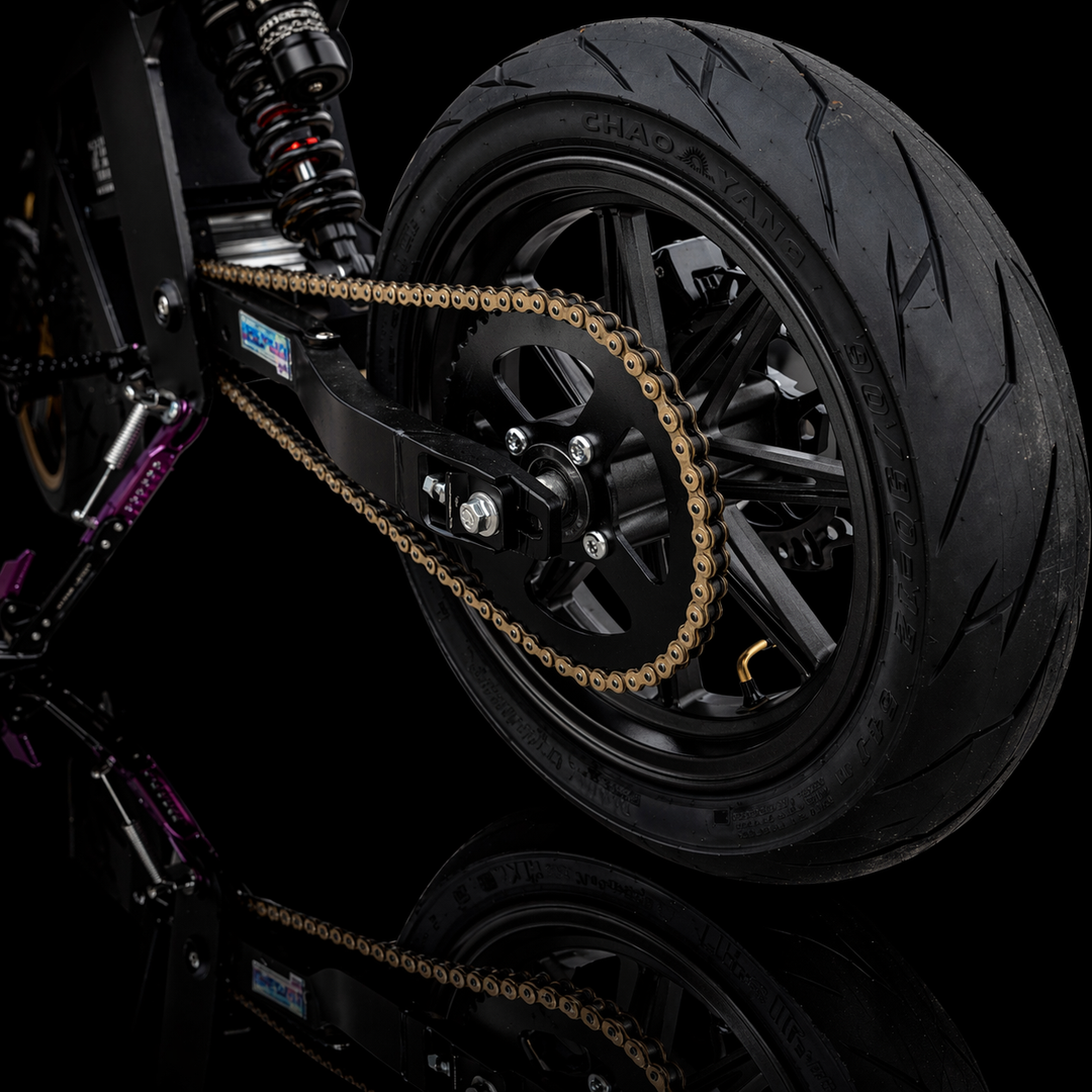Close-up of a motorcycle wheel with chain on a black background