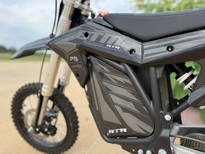 Close-up of a dirt bike with 'ATA' branding on a blurred background