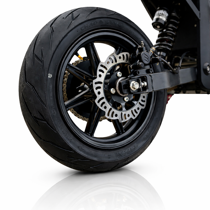 Close-up of a motorcycle wheel with tire and suspension on a white background