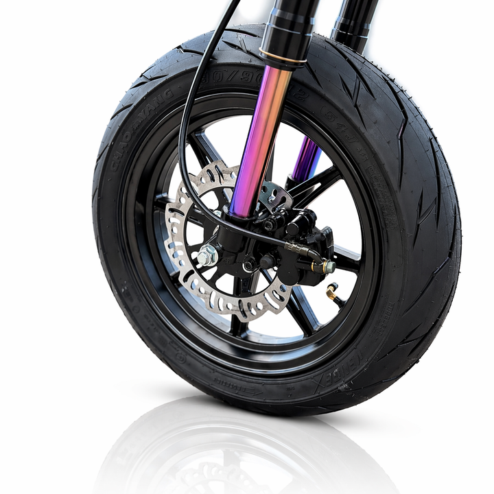 Close-up of a motorcycle wheel with a colorful suspension fork on a white background