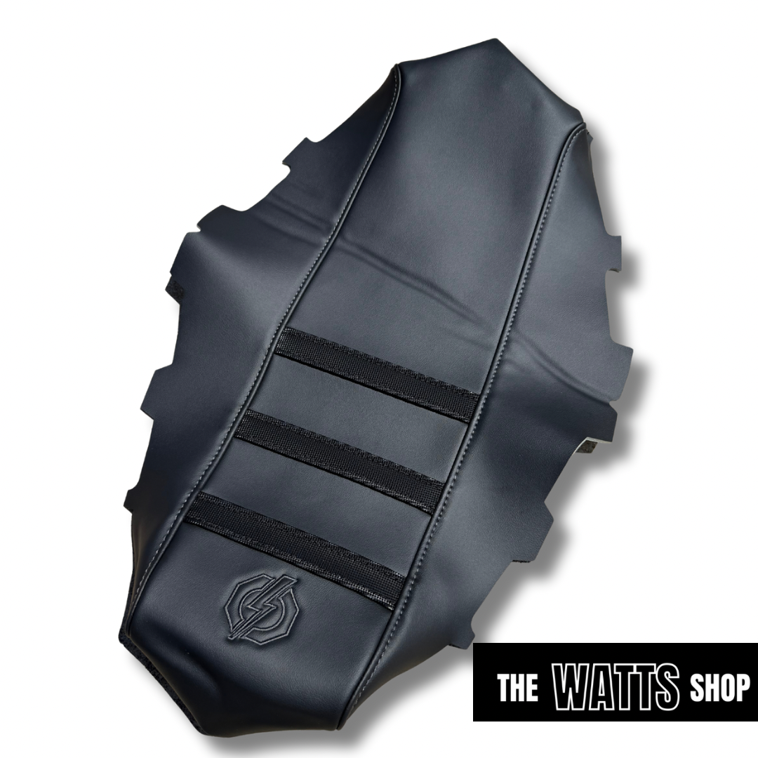 Black leather motorcycle seat with 'The Watts Shop' branding on a white background